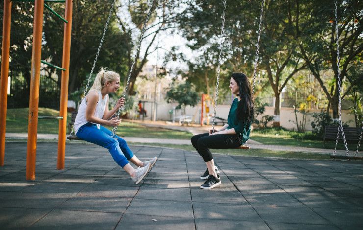two people sitting on swings
