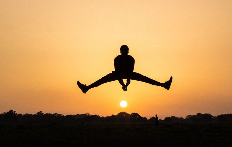 person jumping in sunset