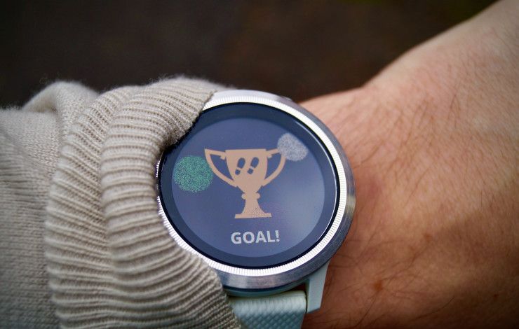 wrist with watch with a trophy and the word goal