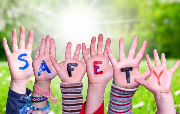 Children's hands with letters painted spelling safety