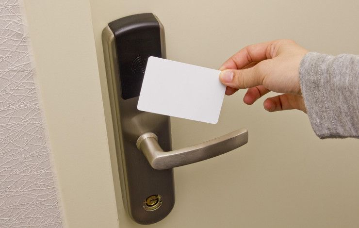 A person using a swipe card on a door