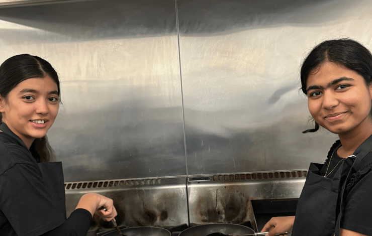 Two young people cooking on a stove