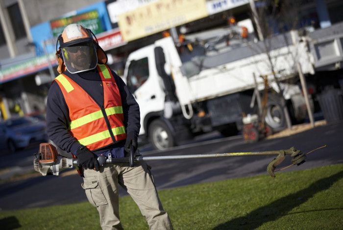 Outdoor staff member holding a whipper snipper