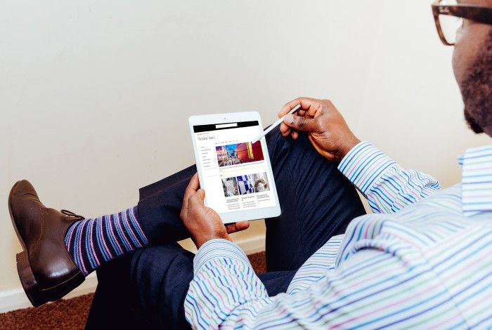 Man reading Source Enews on tablet