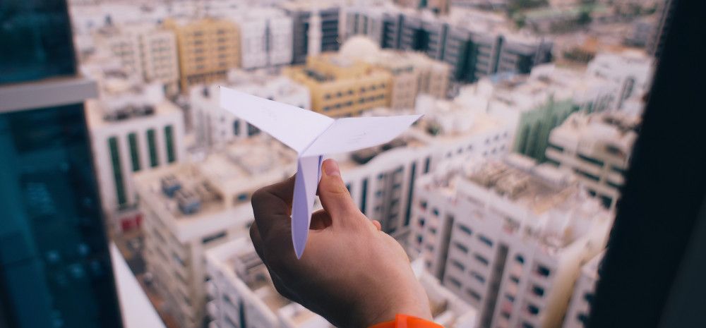 paper plane over a city