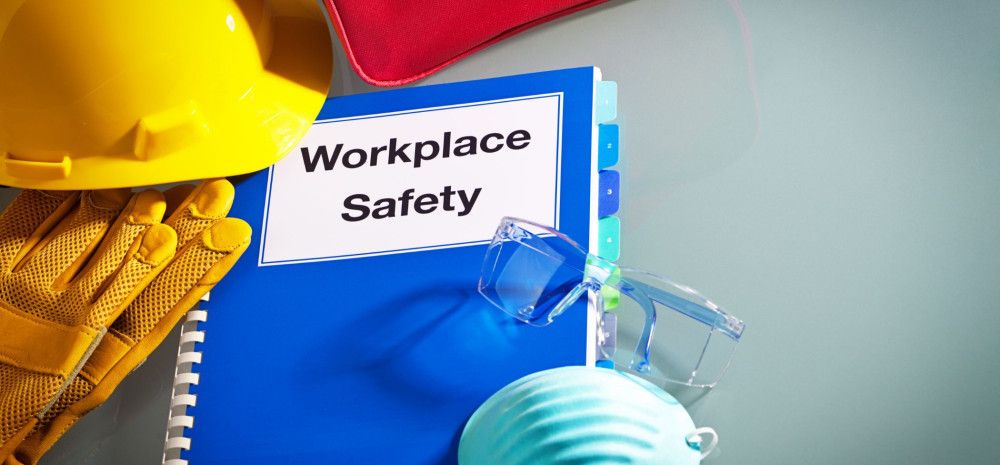 A book with the words 'Workplace Safety' with a hard hat and glasses