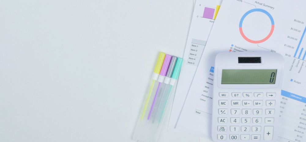 a desk with calculator and pens