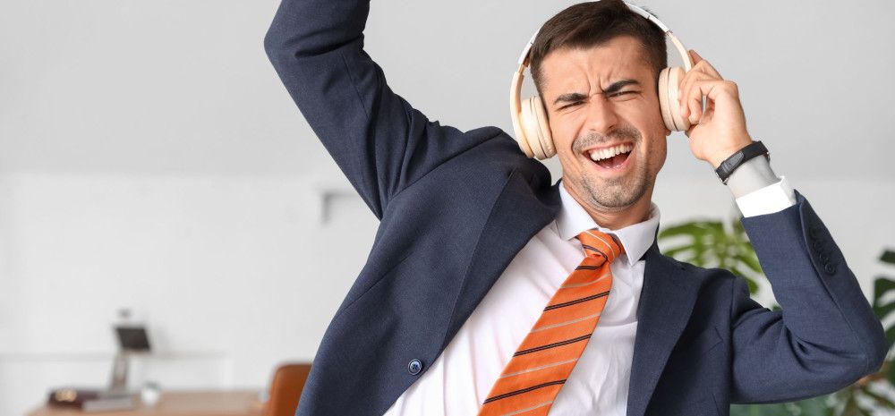 a person in a suit dancing with headphones on