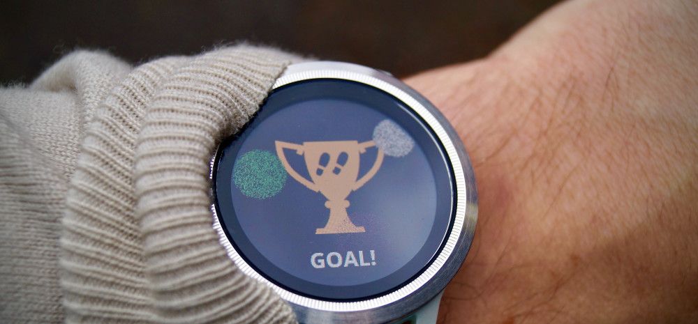 wrist with watch with a trophy and the word goal