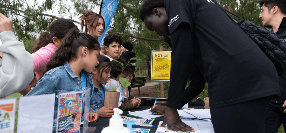 young people chatting to children at a stall at an event