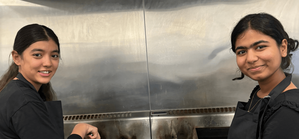 Two young people cooking on a stove