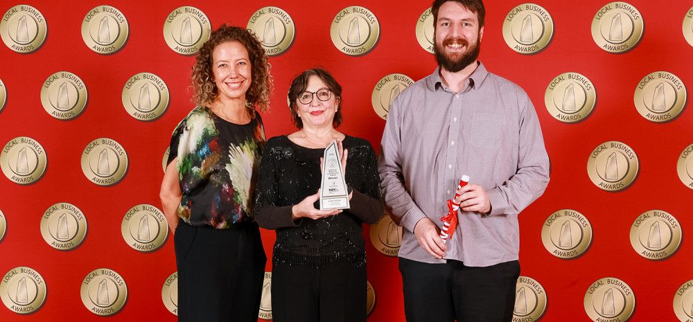 Three people holding an award