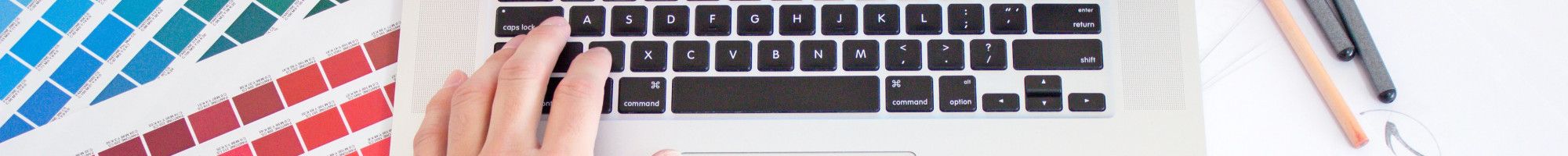 Graphic designer working on laptop and sketch pad