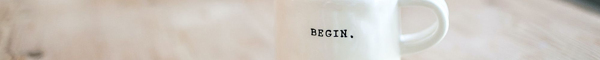 Mug on a table with the word 'begin' on it