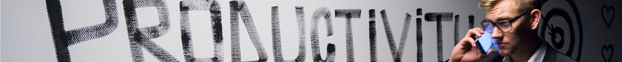 Man walking past a wall with the word Productivity painted on it