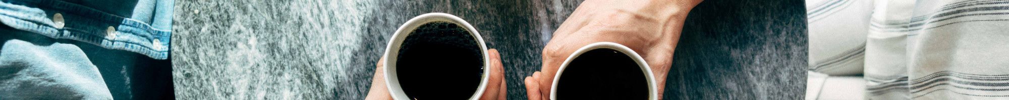 two people sitting at a table with coffee