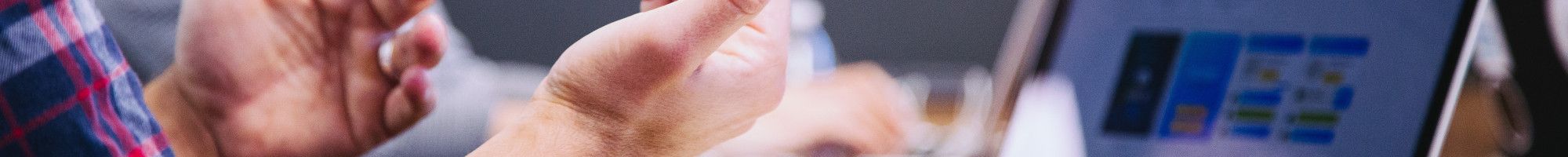 person's hands at desk with laptop