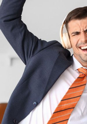 a person in a suit dancing with headphones on
